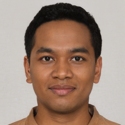 Joyful black young-adult male with short  black hair and brown eyes