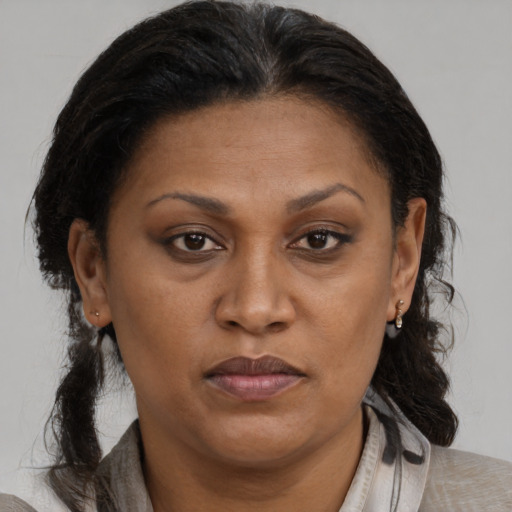 Joyful black adult female with medium  brown hair and brown eyes