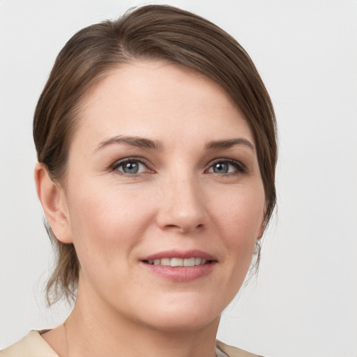 Joyful white young-adult female with medium  brown hair and grey eyes