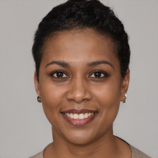 Joyful black young-adult female with short  black hair and brown eyes