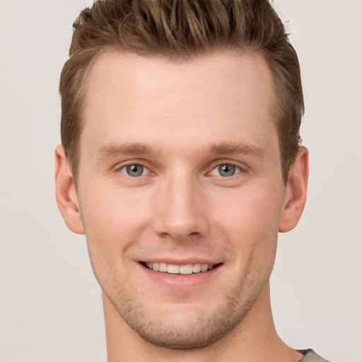 Joyful white young-adult male with short  brown hair and grey eyes