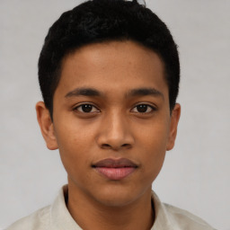 Joyful latino young-adult male with short  black hair and brown eyes