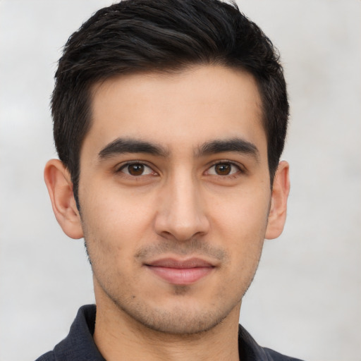 Joyful latino young-adult male with short  brown hair and brown eyes