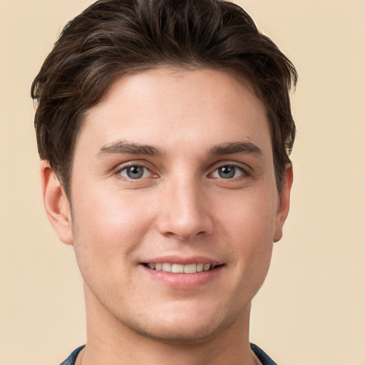 Joyful white young-adult male with short  brown hair and grey eyes