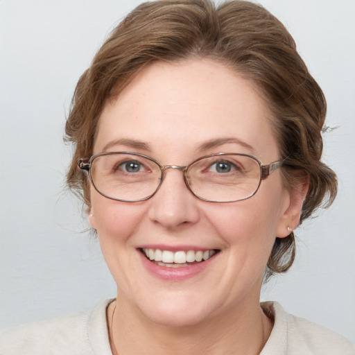 Joyful white adult female with medium  brown hair and blue eyes