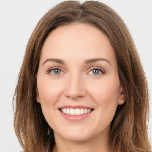 Joyful white young-adult female with long  brown hair and green eyes