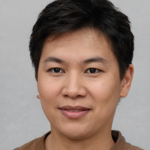 Joyful asian young-adult male with short  brown hair and brown eyes