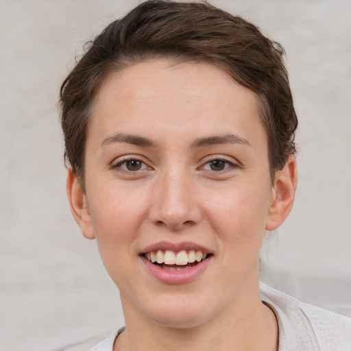 Joyful white young-adult female with short  brown hair and grey eyes