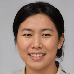 Joyful asian young-adult female with medium  brown hair and brown eyes