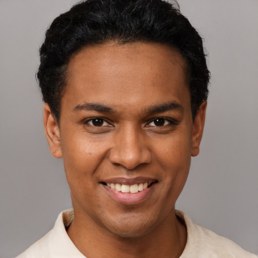 Joyful black young-adult male with short  brown hair and brown eyes