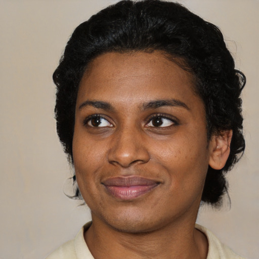 Joyful black young-adult female with short  black hair and brown eyes