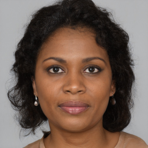 Joyful black young-adult female with long  brown hair and brown eyes