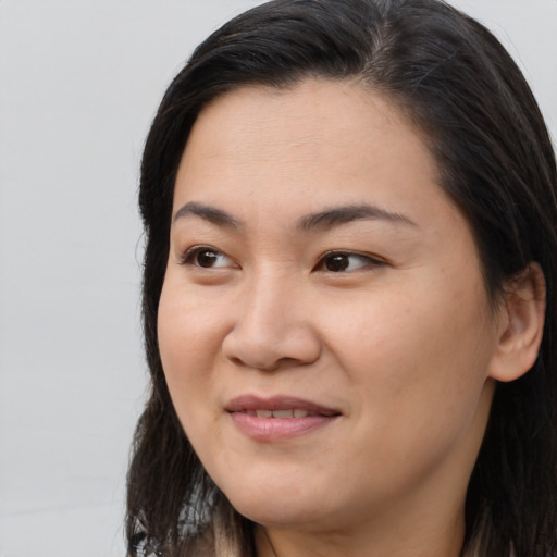 Joyful asian young-adult female with long  brown hair and brown eyes
