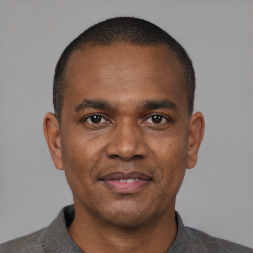 Joyful black adult male with short  black hair and brown eyes