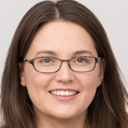 Joyful white young-adult female with long  brown hair and grey eyes