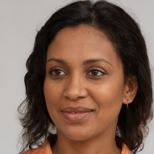 Joyful black adult female with medium  brown hair and brown eyes