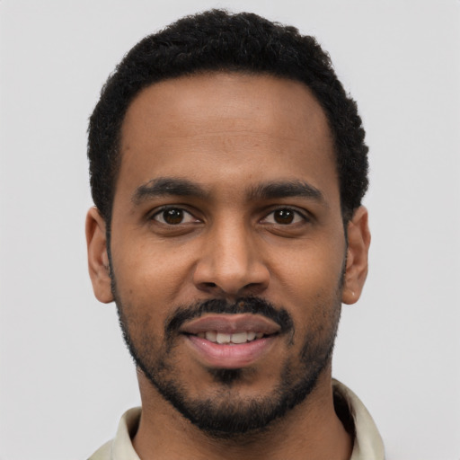 Joyful black young-adult male with short  black hair and brown eyes