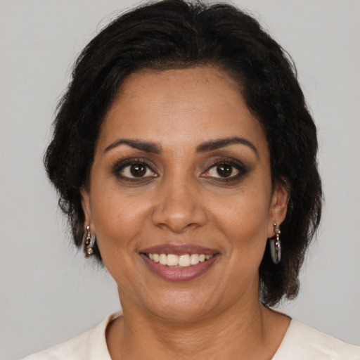Joyful black adult female with medium  brown hair and brown eyes