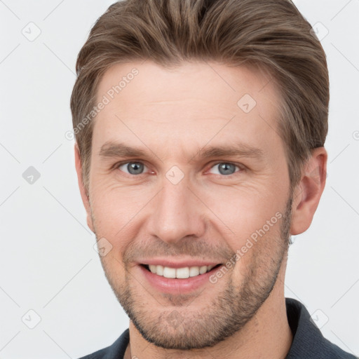 Joyful white young-adult male with short  brown hair and grey eyes