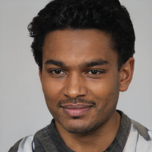 Joyful black young-adult male with short  black hair and brown eyes