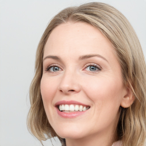 Joyful white young-adult female with long  brown hair and blue eyes