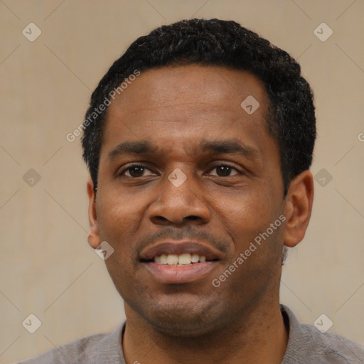 Joyful black adult male with short  black hair and brown eyes