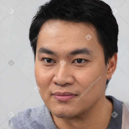 Joyful asian young-adult male with short  black hair and brown eyes