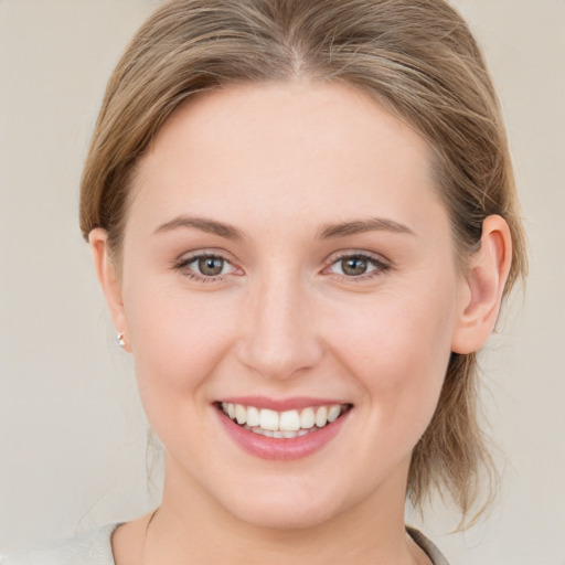 Joyful white young-adult female with medium  brown hair and green eyes