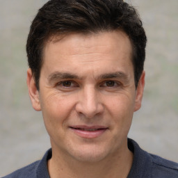 Joyful white adult male with short  brown hair and brown eyes