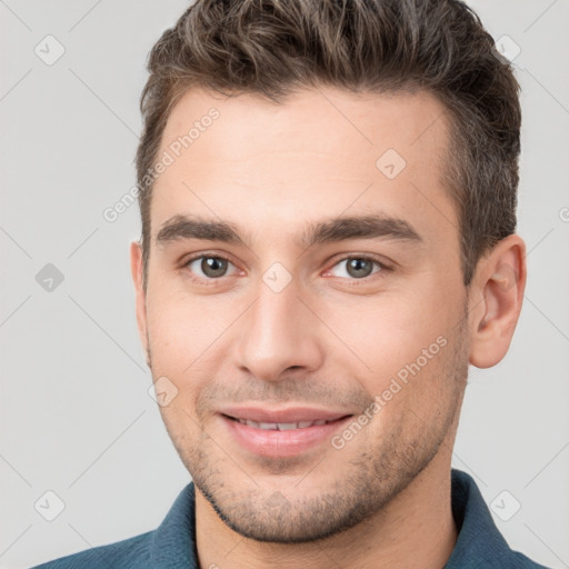 Joyful white young-adult male with short  brown hair and brown eyes