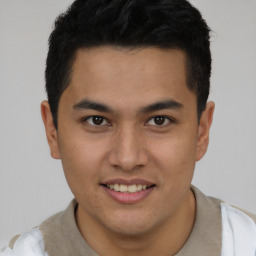 Joyful latino young-adult male with short  brown hair and brown eyes