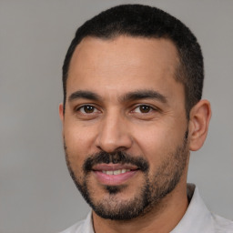 Joyful latino young-adult male with short  black hair and brown eyes