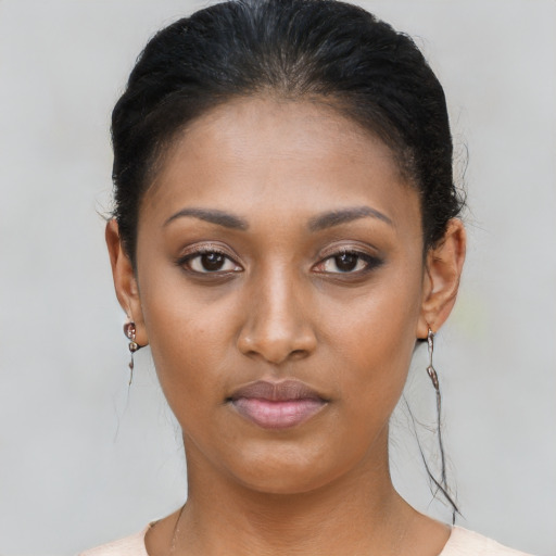 Joyful black young-adult female with short  brown hair and brown eyes