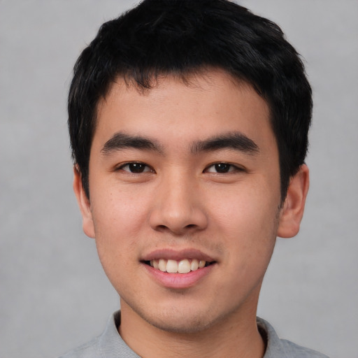 Joyful asian young-adult male with short  black hair and brown eyes