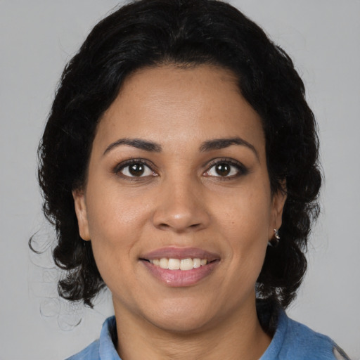 Joyful latino young-adult female with medium  brown hair and brown eyes