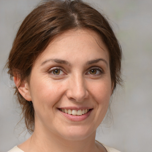 Joyful white adult female with medium  brown hair and brown eyes