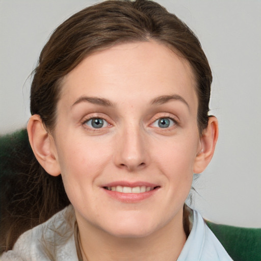 Joyful white young-adult female with medium  brown hair and green eyes