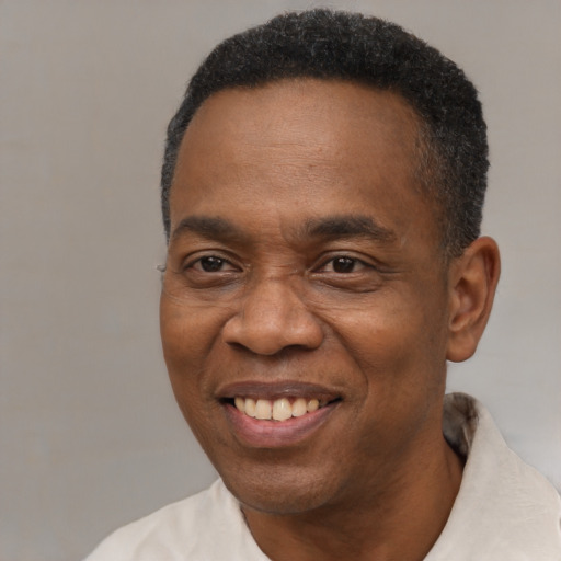 Joyful black adult male with short  black hair and brown eyes