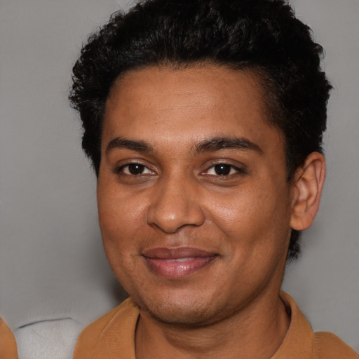 Joyful black young-adult male with short  black hair and brown eyes