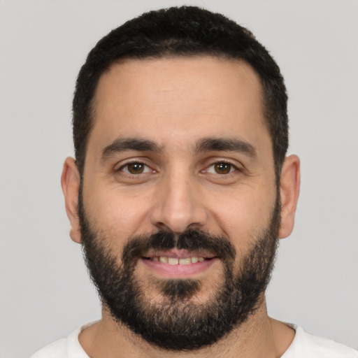 Joyful white young-adult male with short  black hair and brown eyes