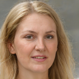 Joyful white adult female with long  brown hair and grey eyes