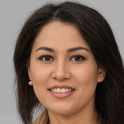 Joyful latino young-adult female with long  brown hair and brown eyes