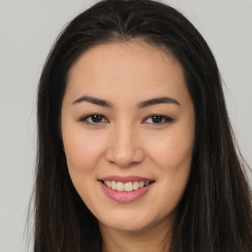 Joyful asian young-adult female with long  brown hair and brown eyes