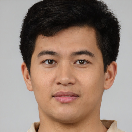 Joyful latino young-adult male with short  brown hair and brown eyes