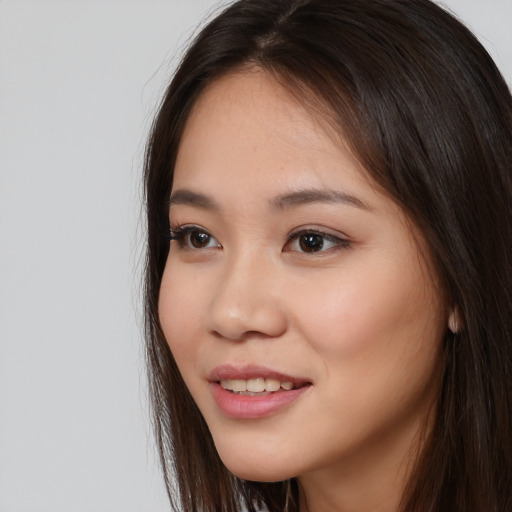 Joyful asian young-adult female with long  brown hair and brown eyes