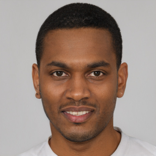 Joyful black young-adult male with short  black hair and brown eyes