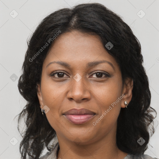 Joyful black adult female with long  brown hair and brown eyes