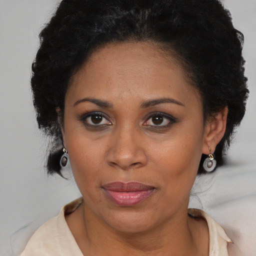 Joyful black adult female with short  brown hair and brown eyes