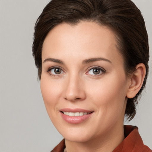 Joyful white young-adult female with medium  brown hair and grey eyes