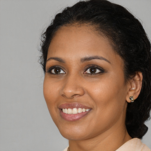 Joyful black young-adult female with medium  black hair and brown eyes